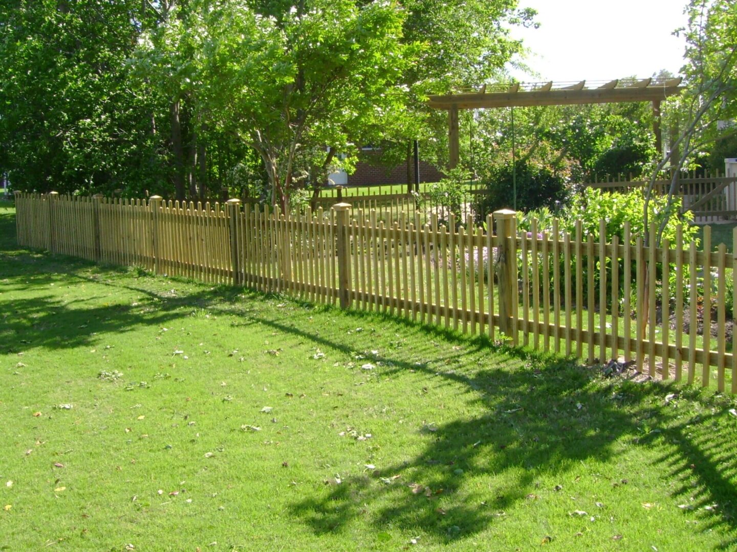 A wooden fence in the middle of a yard.
