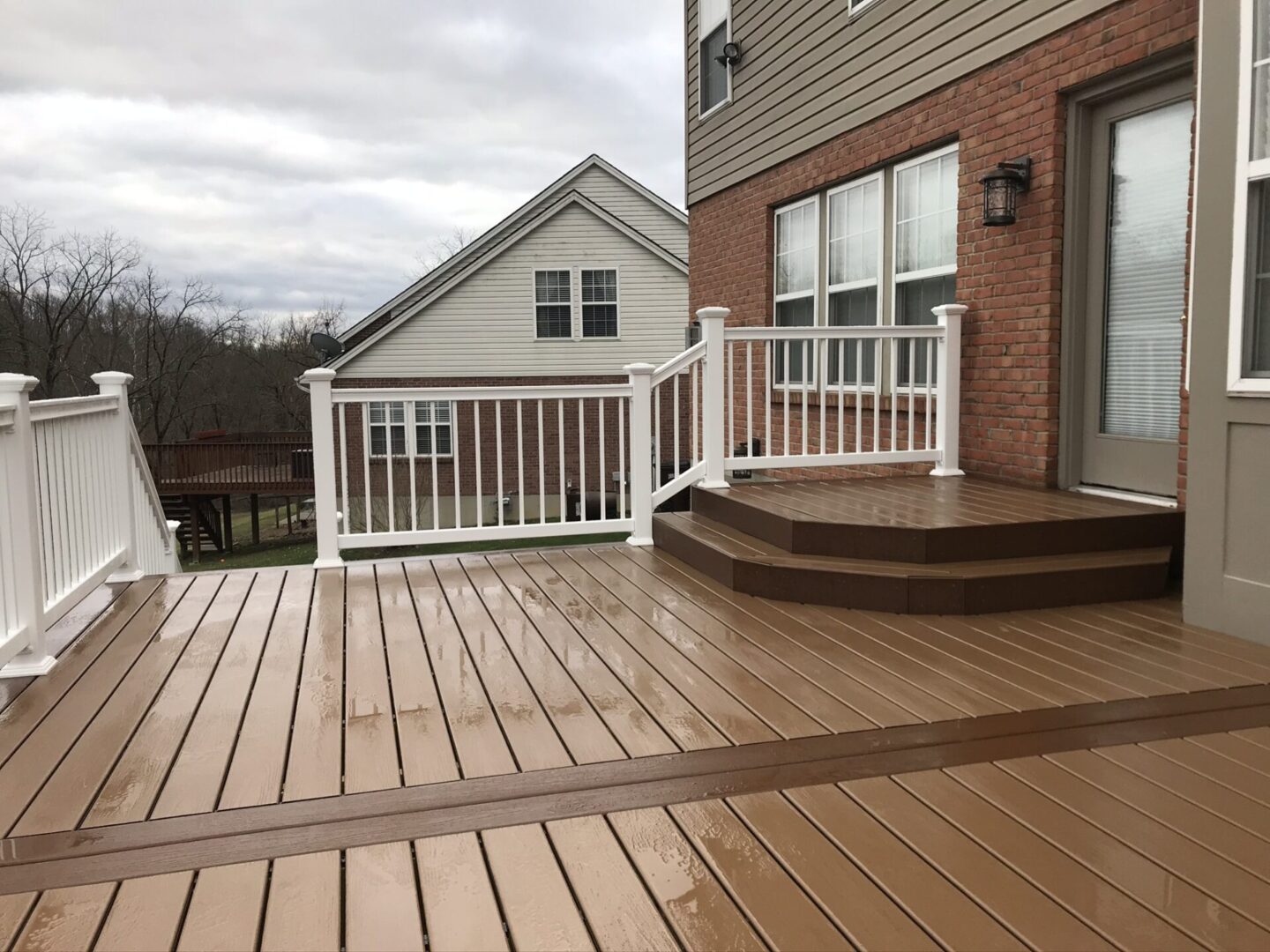 A deck with steps and stairs leading to the back of the house.
