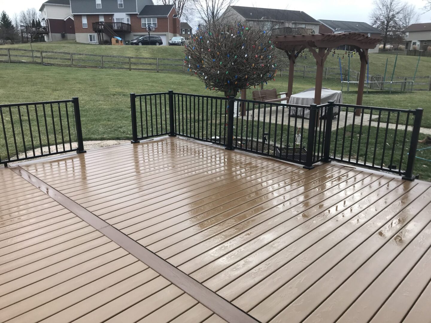 A deck with black railing and brown floor