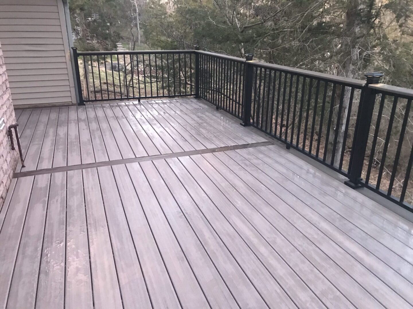 A deck with black railing and white walls