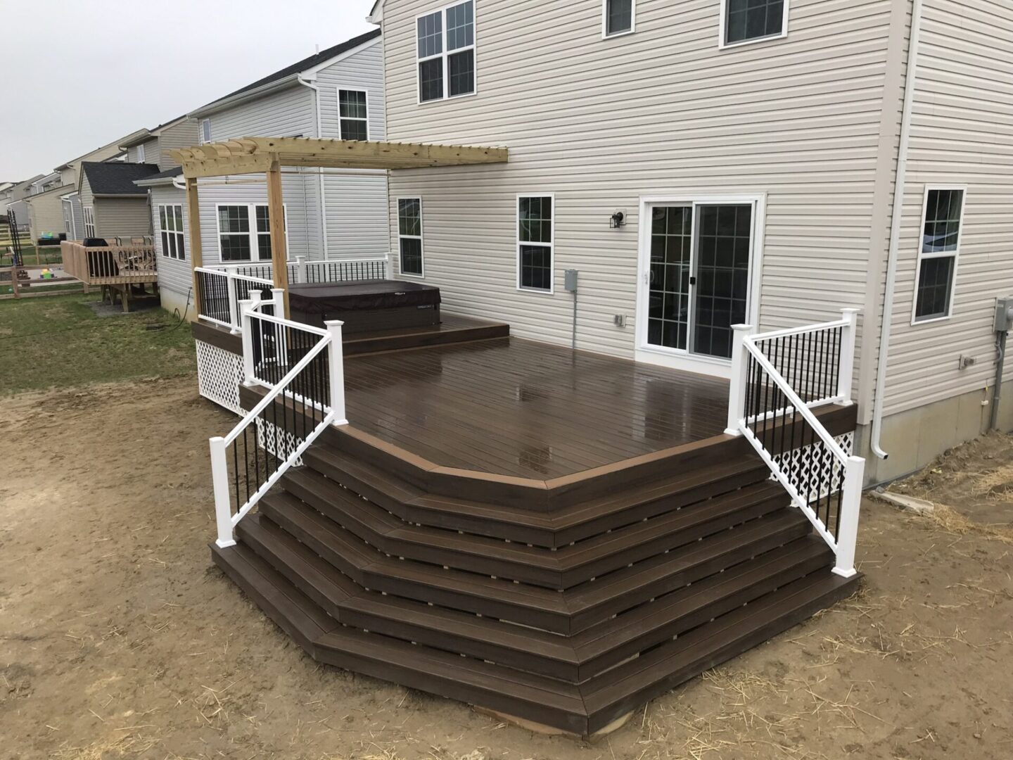 A deck with steps and railings in the middle of it.