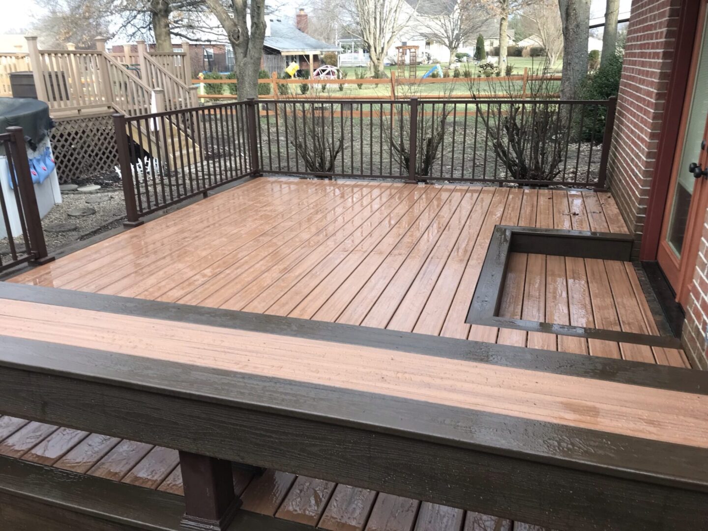 A wooden deck with benches and a fire pit.