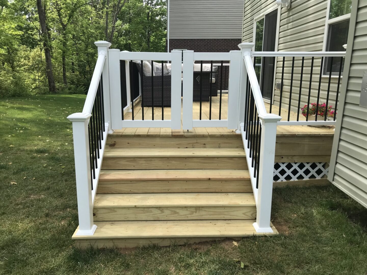A porch with steps and railings that have been painted white.