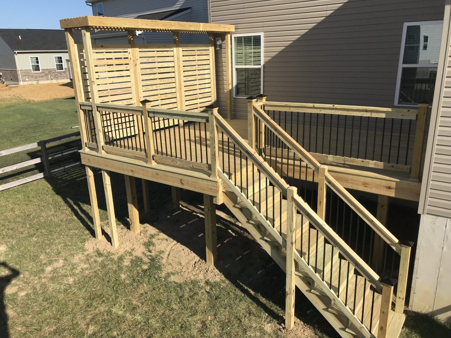 A wooden deck with stairs leading to the back of it.
